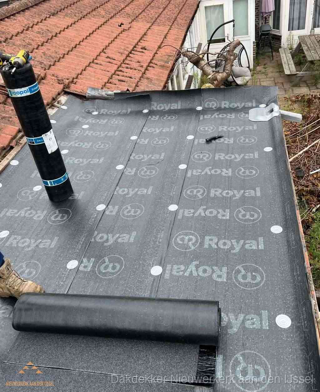 Plat dak met nieuwe bitumen dakbedekking en brandgereedschap in Nieuwerkerk aan den IJssel