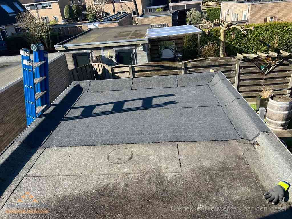 Dakdekker legt onderlaag op plat dak met houten constructie in Nieuwerkerk aan den IJssel