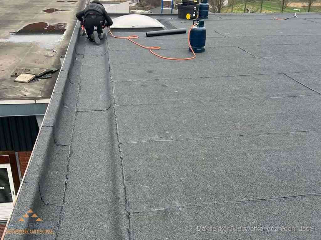 Dakdekker repareert bitumen dakbedekking op groot plat dak in Nieuwerkerk aan den IJssel