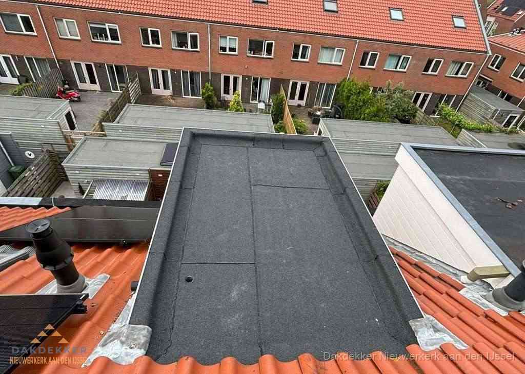 Plat dak met bitumen bedekking naast dakkapel in Nieuwerkerk aan den IJssel