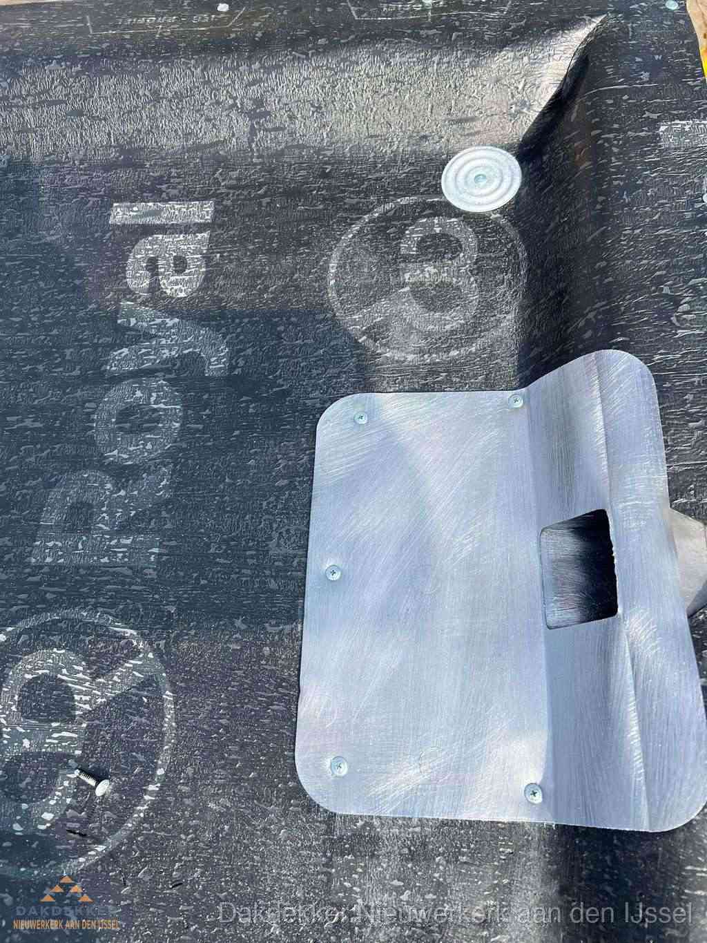 Dakdoorvoer met metalen afvoerplaat op bitumen dak in Nieuwerkerk aan den IJssel