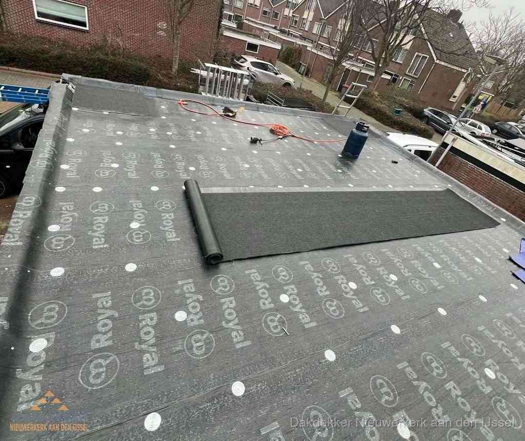 Dakdekker aan het werk met gasbrander op plat bitumen dak in Nieuwerkerk aan den IJssel