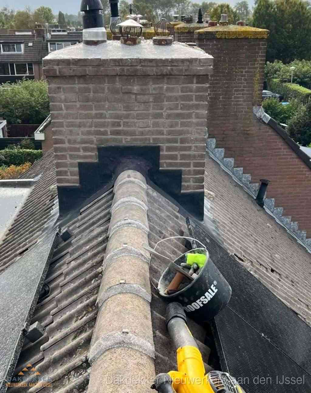 Dakdekker repareert bitumen dakleer bij dakdoorvoer in Nieuwerkerk aan den IJssel