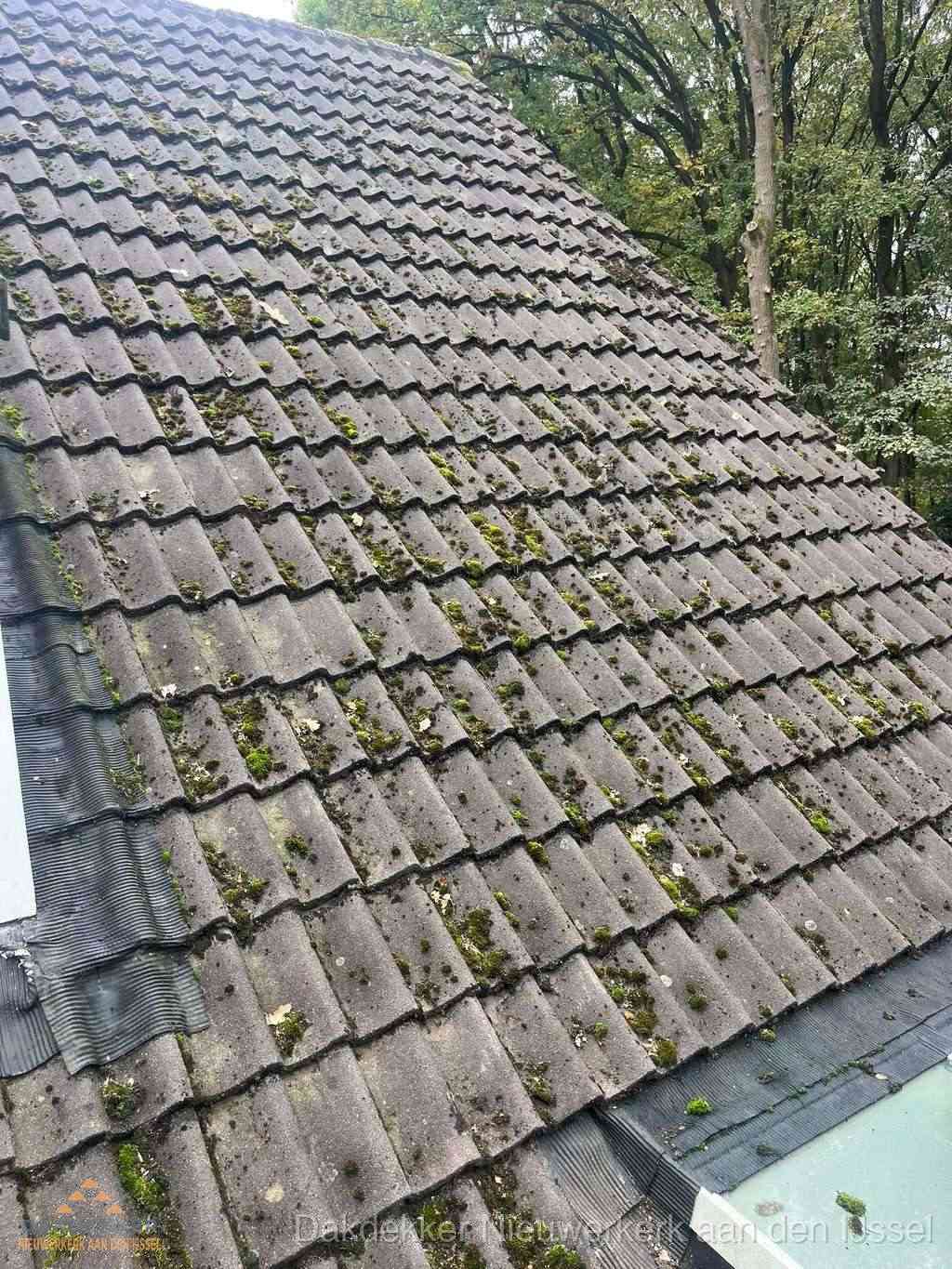 Verweerd pannendak met mosgroei dat renovatie nodig heeft in Nieuwerkerk aan den IJssel