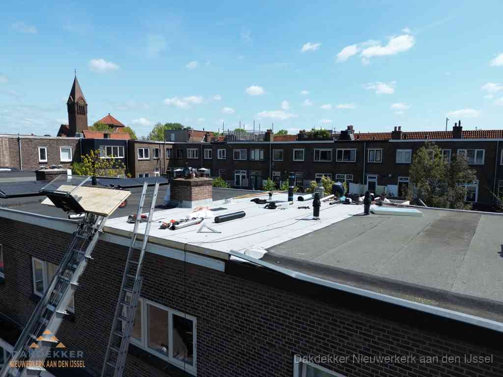 Dakdekkers aan het werk op plat dak in Nieuwerkerk aan den IJssel