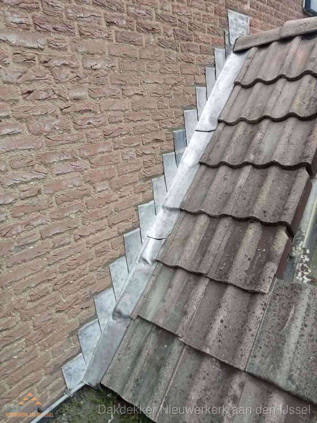 Loodslabben langs dakaansluiting bij bakstenen muur in Nieuwerkerk aan den IJssel